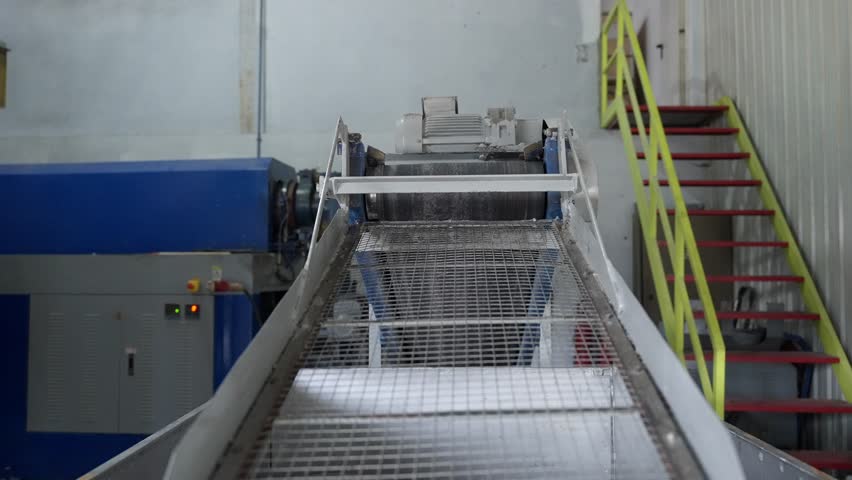 Conveyor system moving material inside rubber recycling factory