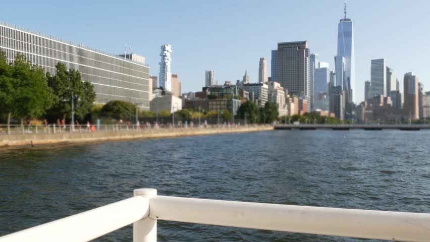 New York City Manhattan downtown financial district skyline, United States. Urban waterfront cityscape with skyscraper buildings, World Trade Center tower from Hudson River Park, riverfront promenade.