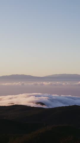 Witness the stunning sunset over La Palma Island towering above the clouds. The vibrant colors of dawn create a magical atmosphere, inviting serenity and wonder.