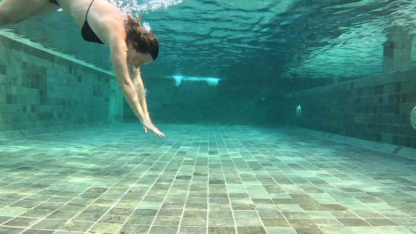 Underwater swimming technique in a pool setting during daylight hours