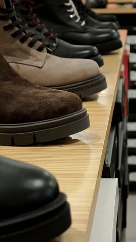 Closeup of brown leather boots on wooden store shelf. Display of quality men