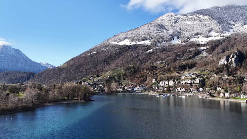 Aerial view of Walensee lake with alpine village and snow covered mountains in Switzerland.