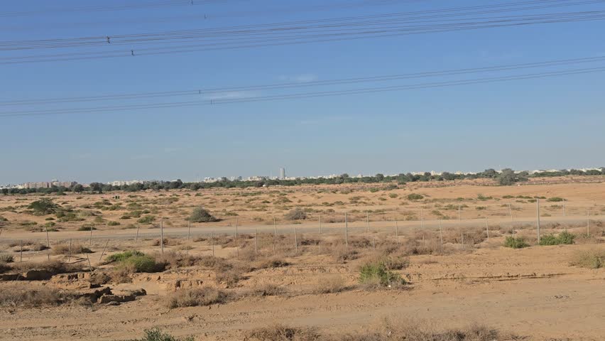 
The image displays undeveloped land  possibly a residential or commercial plot  located in a desert environment in the UAE likely near the Ajman Dubai borde