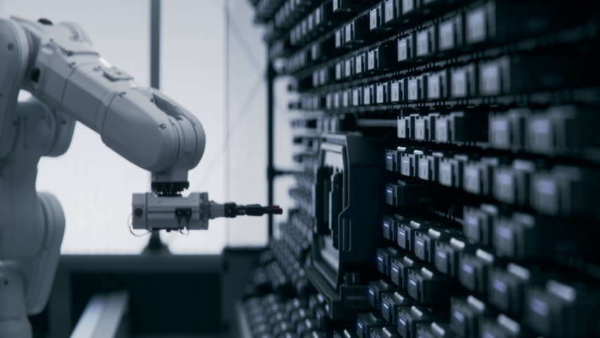 In a Futuristic Data Center Automated Industrial Robotic Arm is Moving and Swaping Hard Drives with Training Data and Datasets that Powers Massive AI Models and LLM. Cloud Computing and Processing Concept