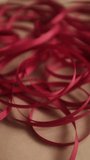 Thin red satin ribbon for wrapping presents. Unfolding a pack or ribbon. Christmas preparation. Valentines day gifts wrapping. - Powered by Shutterstock - Get 15% off with code: PIKWIZARD15