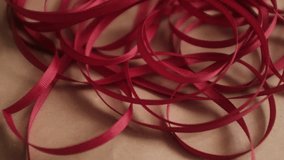 Thin red satin ribbon for wrapping presents. Unfolding a pack or ribbon. Christmas preparation. Valentines day gifts wrapping. - Powered by Shutterstock - Get 15% off with code: PIKWIZARD15