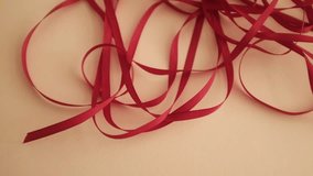 Thin red satin ribbon for wrapping presents. Unfolding a pack or ribbon. Christmas preparation. Valentines day gifts wrapping. - Powered by Shutterstock - Get 15% off with code: PIKWIZARD15