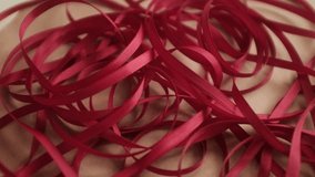 Thin red satin ribbon for wrapping presents. Unfolding a pack or ribbon. Christmas preparation. Valentines day gifts wrapping. - Powered by Shutterstock - Get 15% off with code: PIKWIZARD15