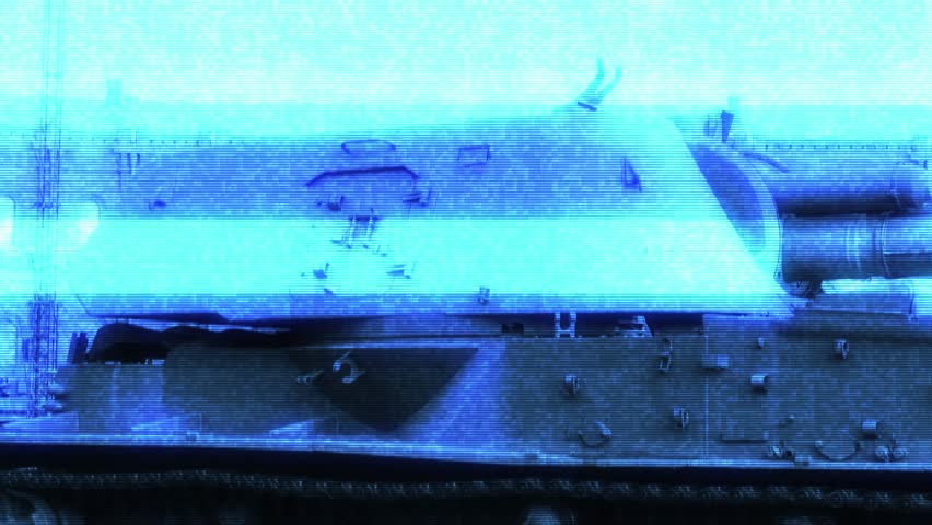 A large military tank sits atop a field, waiting for action.