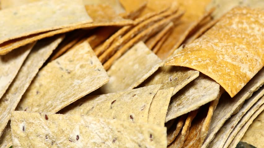A stack of tortilla chips arranged neatly on a table, perfect for snacking or serving at parties.