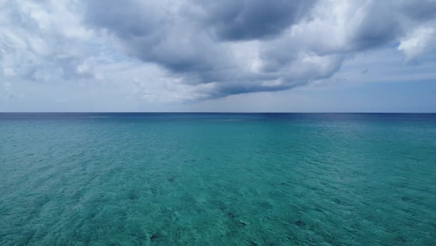 Top view drone footage showing turquoise ocean waters and boats positioned over natural sandbanks. Clear sea textures and tranquil tropical scenery.