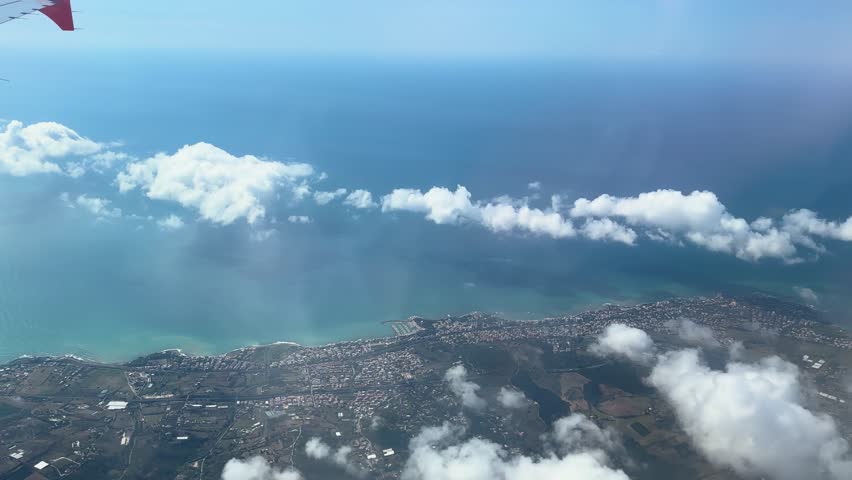quaint town lies below easyjet plane flies lake distant sea under cloudy sky varied landscapes above en route rome to from aerial view air travel scenic flight aircraft