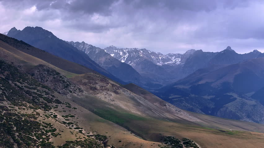 Mountain Ridge and Snowy Peaks in Clouds Kyrgyzstan