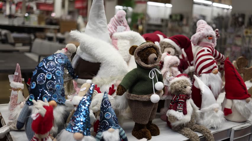 Festive christmas gnomes and teddy bear plush toys displayed on store table creating cozy seasonal retail scene inside holiday decor shop