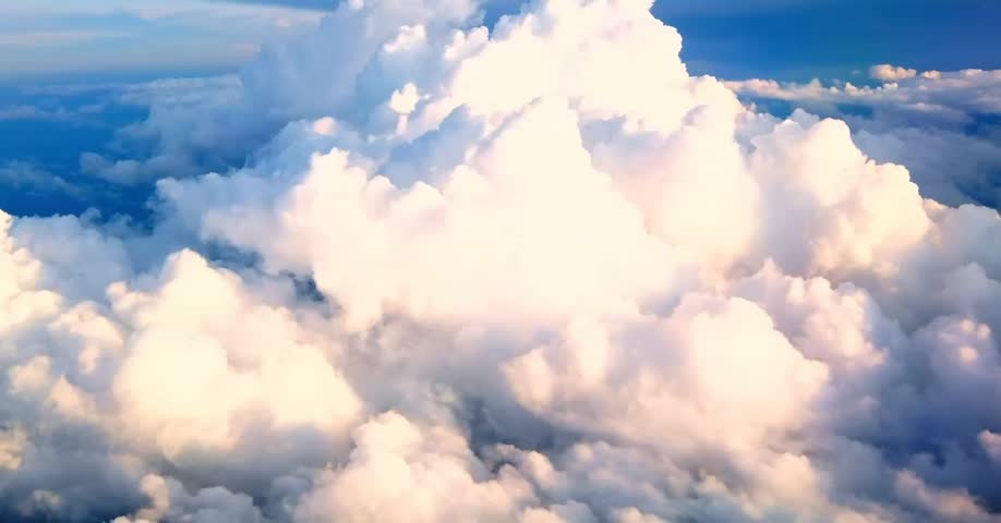 Aerial view of fluffy white clouds and blue sky.