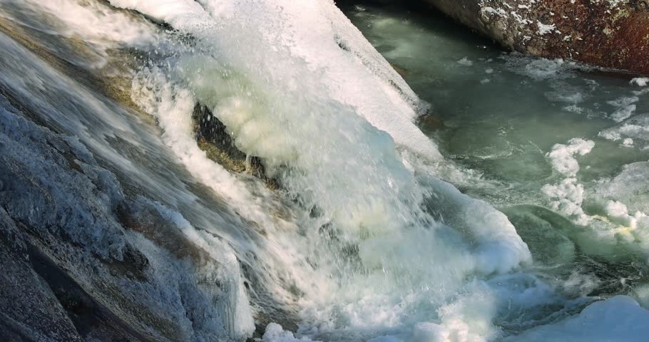 Captured is a cascading waterfall, partially frozen, its waters a vibrant dance between solid ice and flowing stream, a blend of textures and contrasts. High Tatras National Park, Slovakia, Europe.