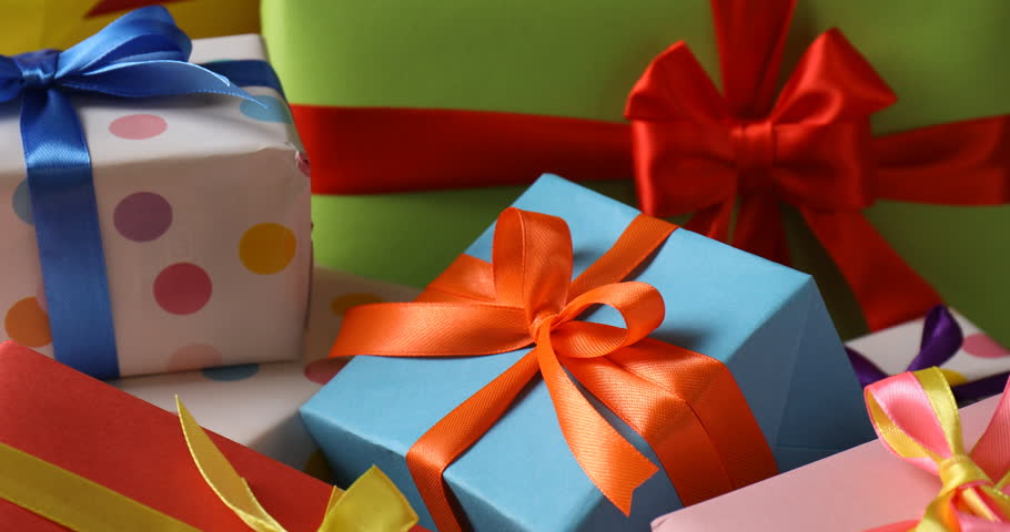 Woman taking beautiful wrapped gift from grey table, closeup