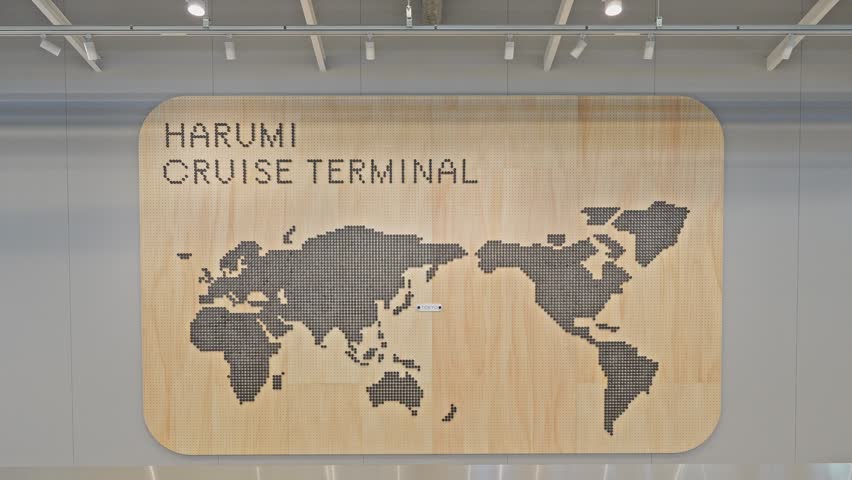 Modern interior of Harumi Cruise Terminal in Tokyo, Japan, featuring a light wood wall with a world map sign.