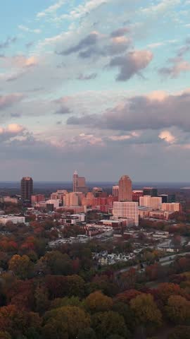Vertical aerial panorama of Raleigh city surrounded by autumn landscape in North Carolina, USA.