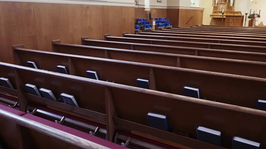 Walking down aisles of a church looking at Bibles, candles, and wooden church pews.