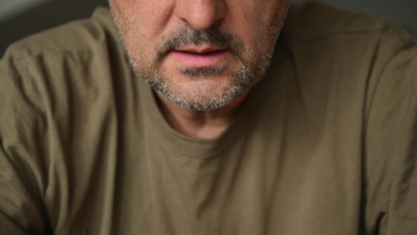 Closeup of unshaved mature man’s mouth while talking, casual appearance, natural expression and realism concept. 4K with selective focus.