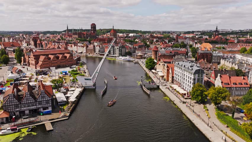 Cinematic drone approach toward drawbridge promenade in Gdansk Old Town