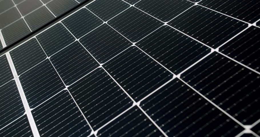Surface of solar panels in daytime. Closeup handheld shot of modern photovoltaic panels illuminated with sunlight in daytime on solar farm. Concept renewable energy, technology, electricity, future.