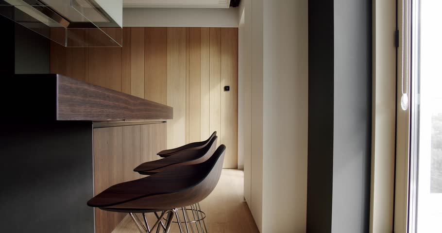 Modern interior in luxury house. Interior of a minimalist kitchen. Light Wood Wall and Floors.Modern kitchen and bar brown chairs in kitchen room in minimalist apartment.kitchen room with natural wood