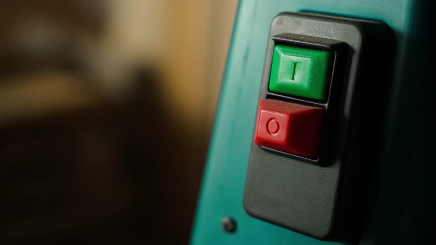 A sticker with the word ERROR is placed under the emergency stop and start buttons of an industrial machine.