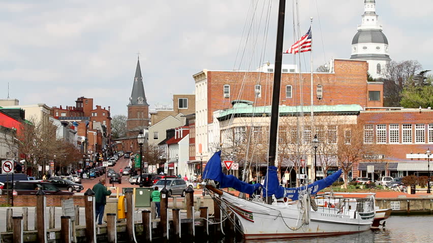 ANNAPOLIS, MARYLAND, USA - APRIL 12, 2013: Tourists shop along the waterfront in historic downtown Annapolis, Maryland, USA, the state capital, dome visible in the background, on April 12, 2013.