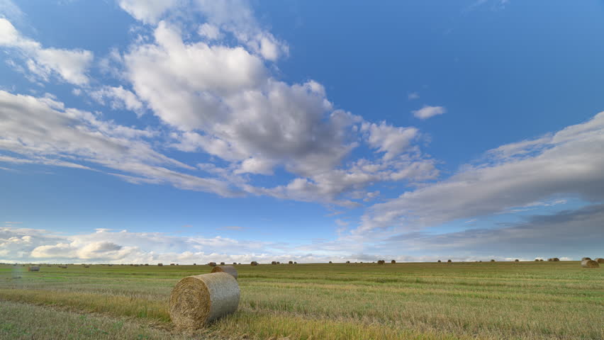 A beautiful scenic landscape featuring hay bales set against dramatic and colorful skies
