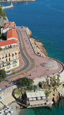 Aerial drone view of Castel Plage beach and the curved coastal road at the foot of Castle Hill, Nice.. Vertical, Nice, France