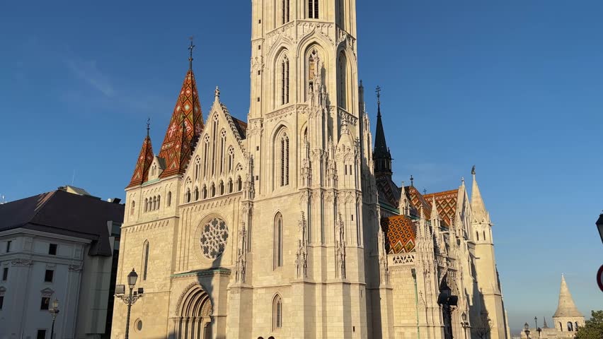 Main west facade of Gothic Matthias Church of the 14th century in Budapest, bottom view close-up while vertical panning against the clear sky
