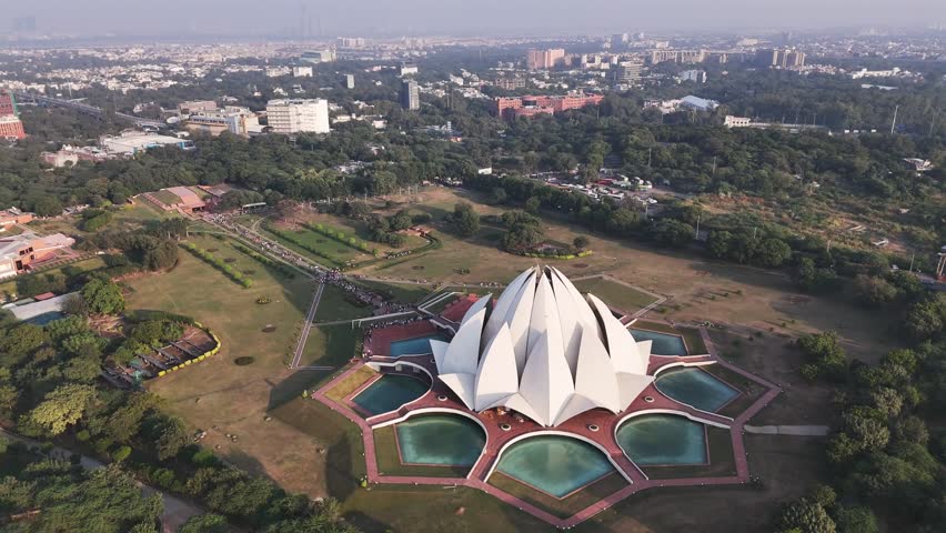 Aerial view of Delhi’s iconic Lotus Temple, its white marble petals unfolding in perfect symmetry, surrounded by tranquil pools and gardens—an enduring symbol of peace, unity, and spiritual harmony.