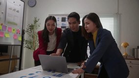 Diverse group of young Asian professionals collaborating on a project. Colleagues discussing business strategy and financial charts in a modern office meeting - Powered by Shutterstock - Get 15% off with code: PIKWIZARD15