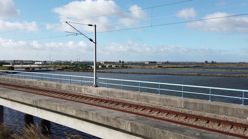Looking over railway line to salt marshes with blue sky