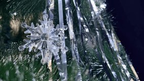 Decorative crystal snowflake ornament hangs from a green pine branch surrounded by shimmering silver tinsel, capturing the festive spirit of holiday decorations in close-up detail - Powered by Shutterstock - Get 15% off with code: PIKWIZARD15