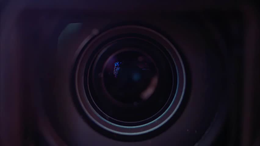 Close-up of a camera lens showing detailed glass elements and reflections, highlighting photography, technology, and professional equipment.