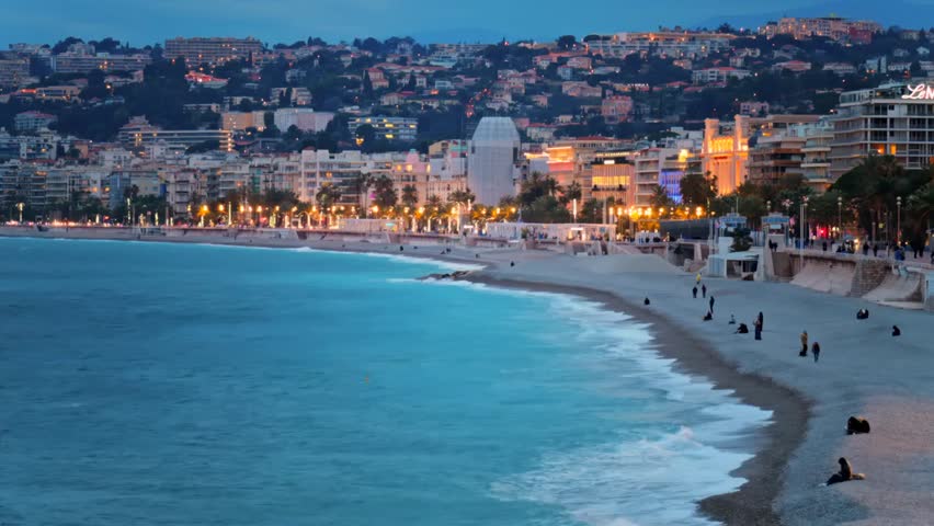 Distant view of the Promenade des Anglais along the Mediterranean coast in Nice, France, capturing evening cityscape, coastal scenery, and urban life.