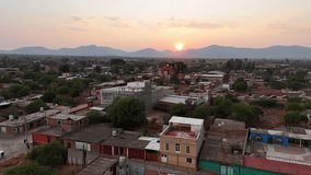 A warm sunset settles over a quiet mountain village, illuminating rustic homes, winding streets, and a historic church dome as soft golden light washes across the valley and distant ridgelines. - Powered by Shutterstock - Get 15% off with code: PIKWIZARD15