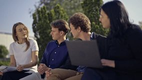 A diverse group of young professionals engages in an informal outdoor business meeting, fostering teamwork and sharing innovative ideas. - Powered by Shutterstock - Get 15% off with code: PIKWIZARD15