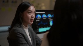 Young asian business women working late at night in an office, discussing and analyzing data on a computer screen for a business project - Powered by Shutterstock - Get 15% off with code: PIKWIZARD15