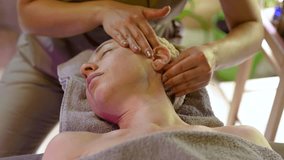 Beautiful middle aged woman getting professional treatment in beauty salon, specialist massaging and relaxing neck muscles to reduce tension and stiffness. Female receiving body massage in clinic - Powered by Shutterstock - Get 15% off with code: PIKWIZARD15