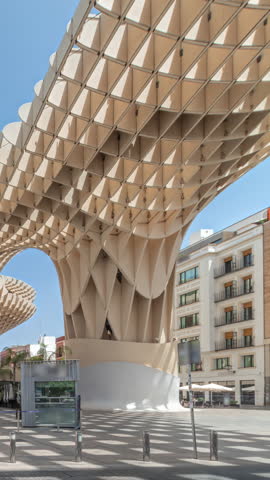 Metropol Parasol in Encarnacion Square timelapse hyperlapse, futuristic wooden structure with panoramic walkway and an archaeological museum. Blue sky, stairs, traffic and cityscape in Seville, Spain