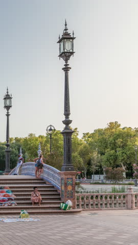 Plaza de Espana in Seville timelapse hyperlapse, a grand architectural complex in Maria Luisa Park built for the Ibero-American Exposition. Bridge with tourists, canal and vintage streetlights