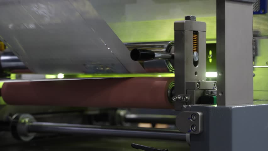 Automated printing. Industrial printing press in action with colorful rollers and sheets moving on automated production line. Modern offset printing technology. High quality mass print  manufacturing