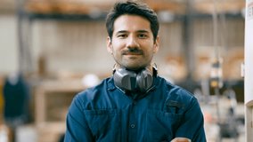 Portrait of a confident and handsome male carpenter with a mustache, smiling at the camera in his woodworking shop with arms crossed - Powered by Shutterstock - Get 15% off with code: PIKWIZARD15