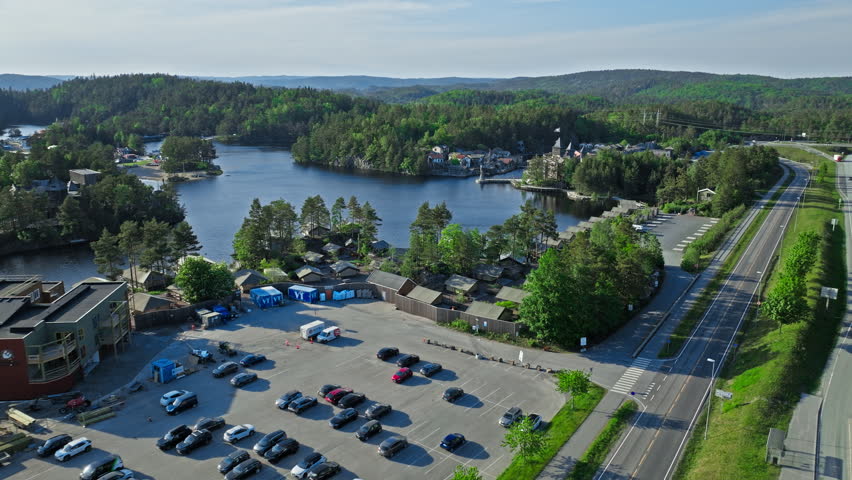 Drone view of Abra Havn and surrounding lakes Kristiansand. Elevated aerial perspective capturing pirate village waterways and forested landscape during calm summer conditions.