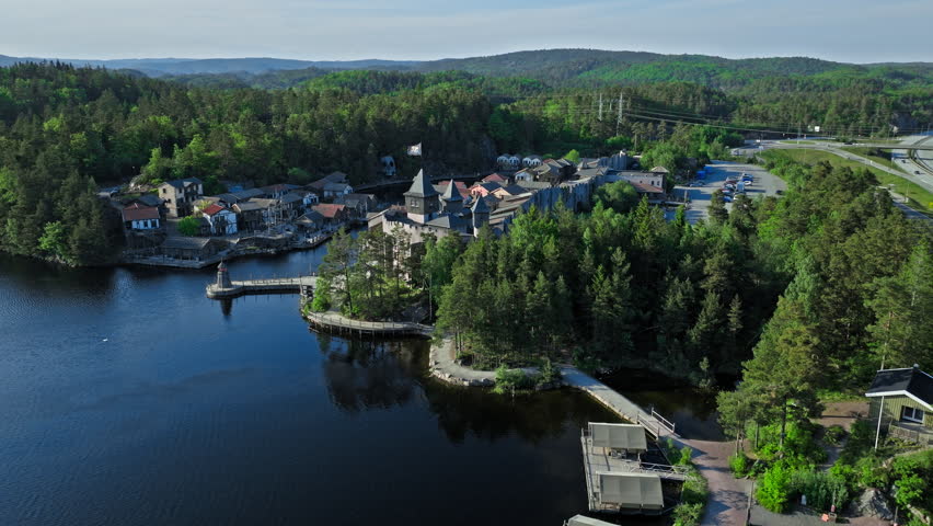 Aerial view of Abra Havn harbor buildings and fortress walls. Drone footage highlighting pirate-style architecture, docks, and water channels on a clear summer day.