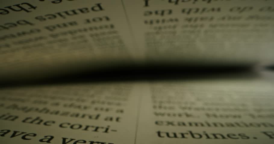 Extreme close-up view of a text in English between the pages in a book, shot inside a book with laowa probe lens with dolly shot. Sliding over lines with text. Reading book. Macro shot